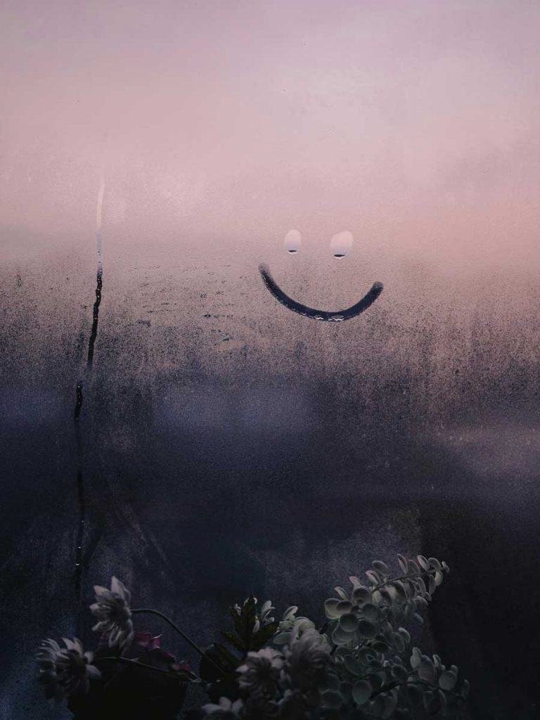 Condensation on a window with pink evening sky. 